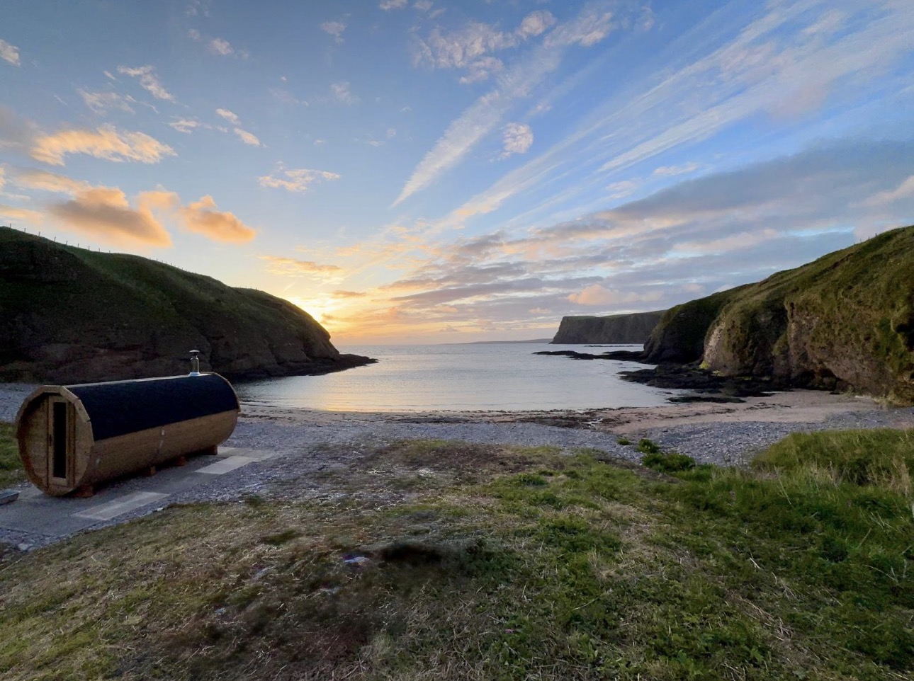 Wood-fired barrel sauna on the shore at Cullykhan Cove at sunset, Moray Firth
